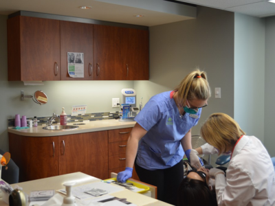 Professional orthodontic team performing dental procedure on patient in a modern Vancouver treatment room